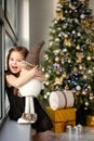 Cute small girl with snowman having fun near Christmas tree indoor. Merry Christmas and Happy New Year