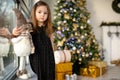 Cute small girl with snowman having fun near Christmas tree indoor. Merry Christmas and Happy New Year