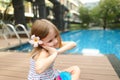 Cute small human girl kid sitting close to swimming pool wearing Royalty Free Stock Photo