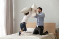 Cute small son playing pillow fight on bed with father Royalty Free Stock Photo