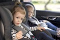 Cute small twins in car seats in the car