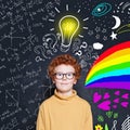 Cute smart boy on blackboard background with idea lightbulb. Science and arts power Royalty Free Stock Photo