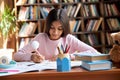 Cute smart hispanic indian school girl studying at table at home. Royalty Free Stock Photo