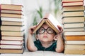 Cute smart preschool girl reading books in library or at home. Kids early learning and home education concept Royalty Free Stock Photo