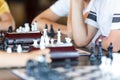 Cute, smart, 11 years old boy in white shirt sits in the classroom and plays chess on the chessboard. Training, lesson, hobby Royalty Free Stock Photo