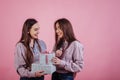 Cute smiles. Two sisters twins standing and posing in the studio with pink background Royalty Free Stock Photo