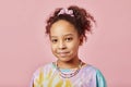 Cute smiling African American girl in t-shirt and necklace looking at camera Royalty Free Stock Photo