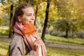 Cute smiling autumn woman holding red maple leaf outdoors. Romantic girl in fall park Royalty Free Stock Photo