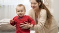 Cute smiling baby boy learning walking with his young mother. Baby development, family playing games, making first steps, Royalty Free Stock Photo