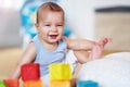Cute smiling baby boy sitting on floor in living room Royalty Free Stock Photo