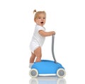 Cute smiling baby girl toddler with toy walker make first steps Royalty Free Stock Photo