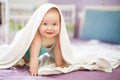 Cute smiling baby looking at camera under a white towel. portrait of a cute child Royalty Free Stock Photo