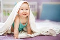 Cute smiling baby looking at camera under a white towel. portrait of a cute child Royalty Free Stock Photo