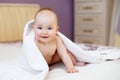Cute smiling baby looking at camera under a white towel. portrait of a cute child Royalty Free Stock Photo