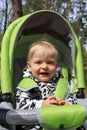 Cute smiling baby in a stroller outddor close up portrait