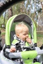 Cute smiling baby in a stroller outddor close up portrait