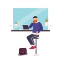 Cute smiling bearded man sitting at cafe, working on laptop computer and talking on mobile phone. Happy freelance worker Royalty Free Stock Photo