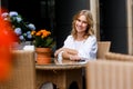 Cute smiling blond girl sitting in cozy cafe Royalty Free Stock Photo