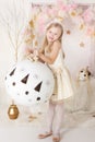 Cute smiling blondy girl with a huge Christmas ball