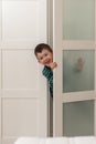Cute smiling boy in wardrobe at home. Peeking, hiding, playing Royalty Free Stock Photo