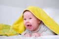 Cute smiling caucasian infant baby looking at camera in yellow towel after bathing in the bath on white bed.Copyspace. Royalty Free Stock Photo