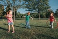 Cute smiling Caucasian preschool girl boys friends playing with hoola hoop in park outside. Kids sport activity. Lifestyle happy Royalty Free Stock Photo