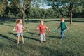 Cute smiling Caucasian preschool girl boys friends playing with hoola hoop in park outside. Kids sport activity. Lifestyle happy Royalty Free Stock Photo