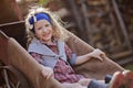 Cute Smiling Child Girl In Spring Garden Sitting In Wheelbarrow