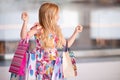 Cute smiling child girl 4-5 year old hold paper bags shopping in store mall making purchases. Buy clothes with season sales.