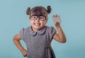 Cute smiling child with glasses holding bank card in her hands.