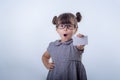 Cute smiling child with glasses holding bank card in her hands.