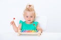 Cute smiling child little blonde baby girl playing with musical toy xylophone isolated on white background Royalty Free Stock Photo