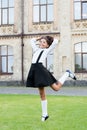 Cute smiling confident schoolgirl jumping. sense of freedom. back to school. Cheerful smart schoolgirl. Ending of school