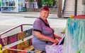 Cute smiling elderly senior woman playing piano, looks at camera with copy space, outdoors park Royalty Free Stock Photo