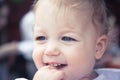 Cute smiling fascinated baby girl portrait with finger in mouth