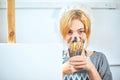 Young smiling girl paints on canvas with oil colors in own workshop. Window on the background. Art concept. Royalty Free Stock Photo