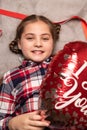 cute smiling girl holding red heart shaped balloon Royalty Free Stock Photo