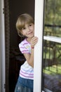 Cute smiling girl looking out balcony door Royalty Free Stock Photo