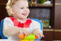 Cute smiling girl rolling plastiline dough