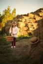 cute smiling girl runs rustic village with wicker basket  long blond hair  hayfield wheat hayloft harvesting feeding warm sunny Royalty Free Stock Photo