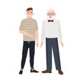 Cute smiling grandfather and grandson standing together. Funny happy elderly man and young guy talking to each other and Royalty Free Stock Photo