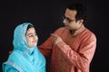 Cute smiling Indian girl in India traditional blue dress with her father standing on black background, dad hugging and pointing at Royalty Free Stock Photo