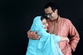 Cute smiling Indian girl in India traditional blue dress with her father standing on black background, daughter kid hugging her Royalty Free Stock Photo