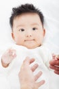 Cute and smiling infant with mother hands