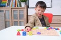 Cute smiling kindergarten boy playing with alphabet blocks, Asian children learning English with wooden educational abc toy puzzle Royalty Free Stock Photo