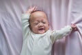 Cute smiling little Asian 2 - 3  months old newborn baby girl child lying in bed wakes up and stretches, Newborn daughter relaxing Royalty Free Stock Photo