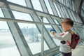 Cute smiling little Asian 2 years old toddler boy child having fun playing with airplane toy while wait for his flight at airport Royalty Free Stock Photo