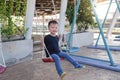 Asian 2 - 3 years old young toddler boy child having fun swinging at children playground on rooftop Royalty Free Stock Photo