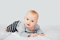 Cute smiling little baby girl sitting on bed. Seven month old infant child on grey soft blanket Royalty Free Stock Photo