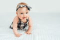 Cute smiling little baby girl sitting on bed. Seven month old infant child on grey soft blanket Royalty Free Stock Photo